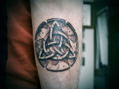 A baby in her father's arms looks at tattoo design. Triquetra Tattoos Designs, Ideas and Meaning | Tattoos For You