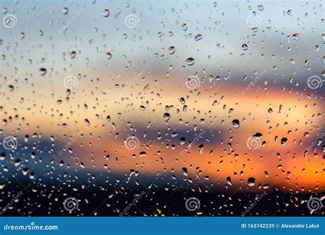 Abstract Photo Of Raindrops On Glass At Sunset With Bokeh Blurred Sun