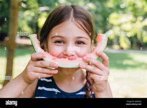 Cute Little Girl Eating Watermelon In Park In Summertime Stock Photo