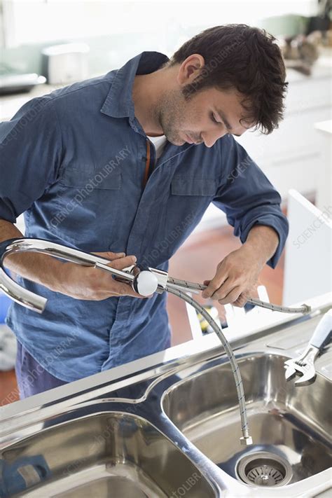 This functional kitchen is perfect to teach toddlers practical life skills. Plumber working on kitchen sink - Stock Image - F013/7929 ...