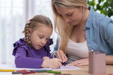 Mother Helps To Daugher With Homework Or School Assignment Together