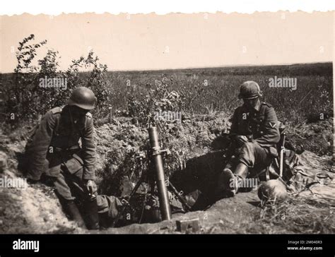 German Army 8cm Mortar Crew Rest In Their Mortar Emplacement On The