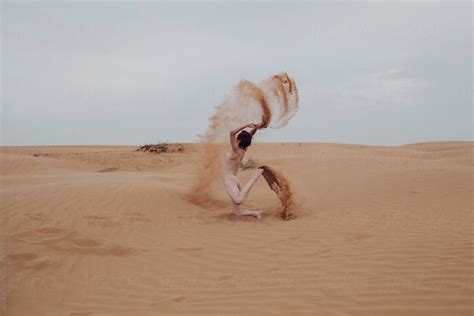 Unrecognizable Female Creating Sand Splashes In Desert By Stocksy Contributor Liliya