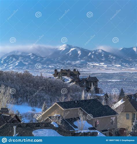 Square Snow Falling On Homes With Sweeping View Of Valley And Towering