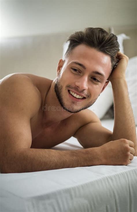 Shirtless Fit Male Model Relaxing Lying On The Grass Stock Photo