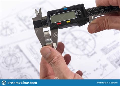 Measuring A Steel Part With A Vernier Caliper In A Persons Hand