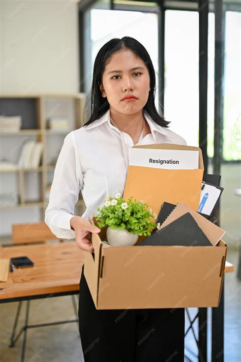Triste Y Disgustada Joven Oficinista Asiática Se Encuentra En La Oficina Con Una Caja De Cartón