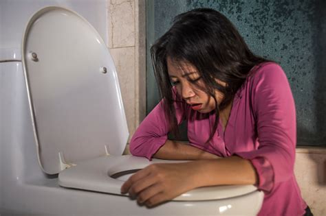 Young Drunk Or Pregnant Asian Woman Vomiting And Throwing Up In Toilet Wc Feeling Unwell And
