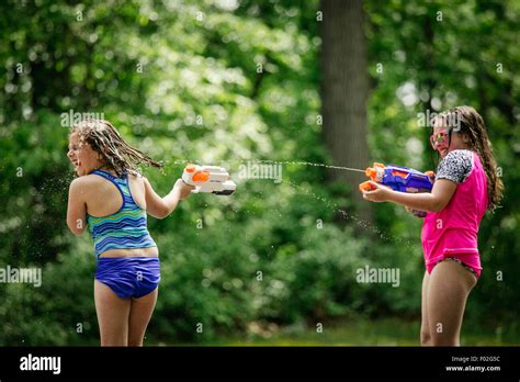 Two Girls Having A Water Gun Fight Stock Photo Alamy