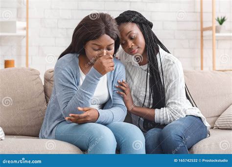 Black Girl Embracing And Comforting Her Upset Friend At Home Stock