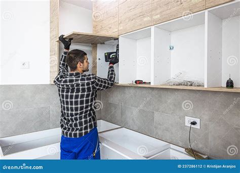 O Carpinteiro Põe A Porta Das Prateleiras Da Cozinha Foto De Stock