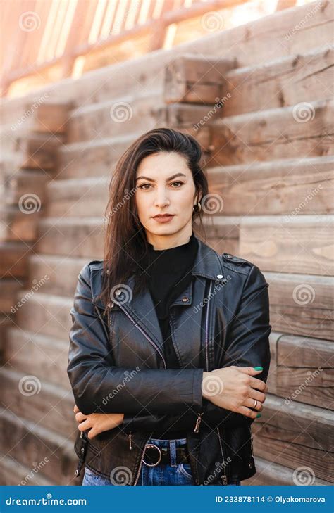 A Young Brunette Woman In A Black Leather Jacket In The Park In The