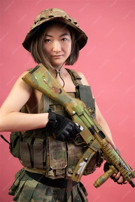 Premium Photo The Sexy Asian Woman In Military Clothes With An Automatic Rifle In Her Hands On