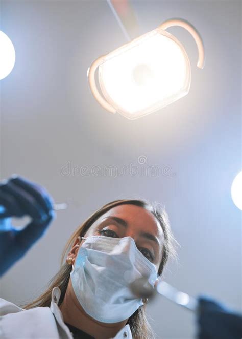 Open Wide Low Angle Pov Shot Of A Focused Young Female Dentist Wearing