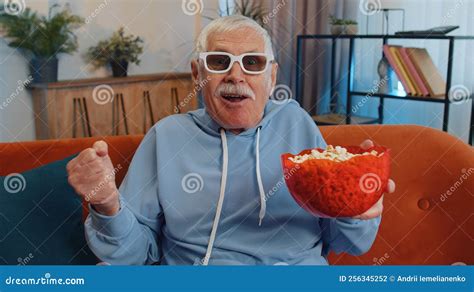 Man Sitting On Couch Eating Popcorn And Watching Interesting Tv Serial