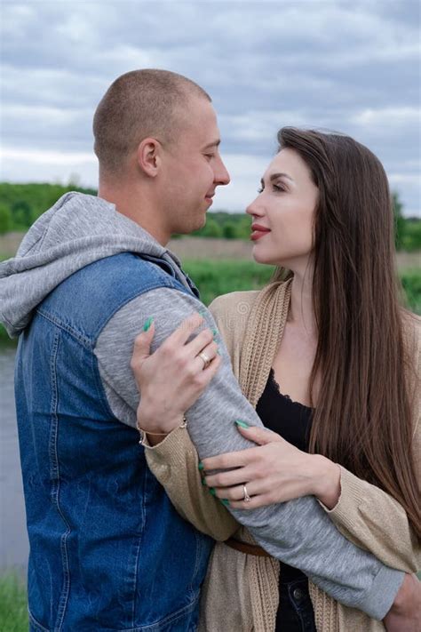 Happy Young Couple Outdoors Near Lake And Green Grass Bald Man And