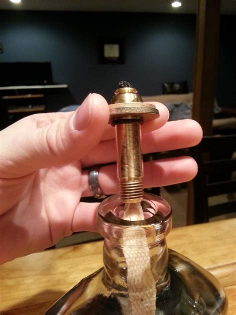 A Person Is Holding An Old Fashioned Perfume Bottle In Their Left Hand