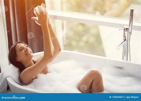Beautiful Woman Relaxing In Bath And Playing With Foam Stock Image