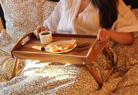 A Woman Is Sitting In Bed With Her Breakfast Tray
