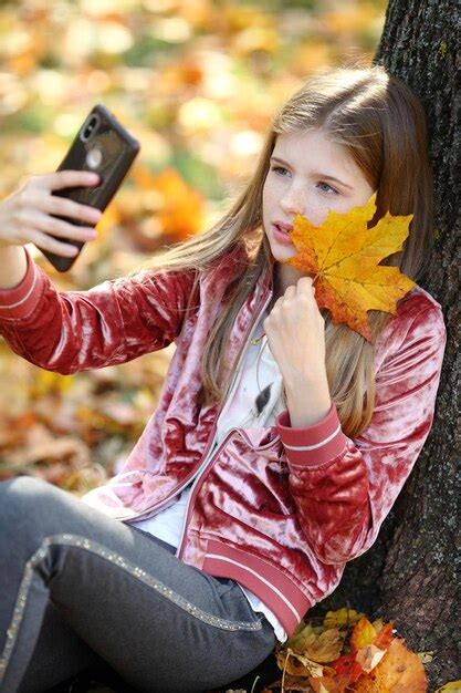 Premium Photo Beautiful Girl Taking Selfie By Smartphone In Autumn City Park