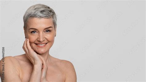 Mature Beauty Portrait of charming nude middle aged woman touching her skin 스톡 사진 Adobe Stock
