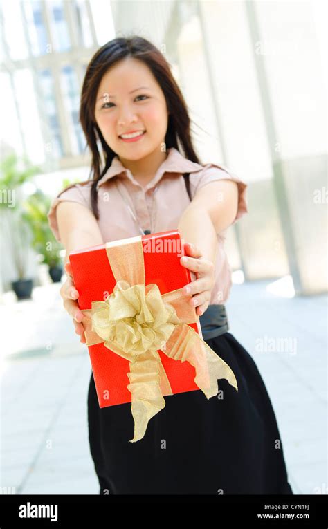 Young Asian Girl Arms Out Holding A Beautiful Wrapped Present Focus Is
