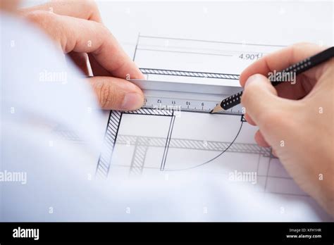 Cropped Image Of Architect Using Ruler And Pencil On Blueprint In