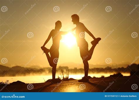 Silhouette Of A Fitness Couple Stretching At Sunset Stock Photo Image