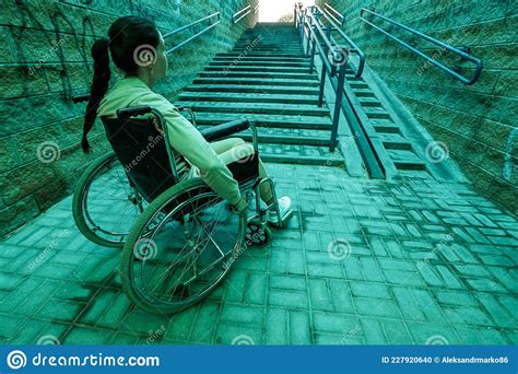A Disabled Girl Sitting In A Wheelchair On The Background Of The Stairs The Concept Of Gray
