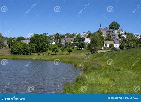 Picturesque Auvergne Village In Spring By A Lake In France Stock Photo