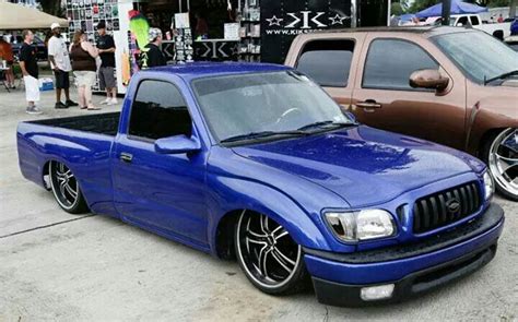 A Blue Pick Up Truck Parked Next To Other Cars