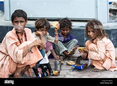 Poor Homeless Children Eating On The Street In Amritsar India Stock