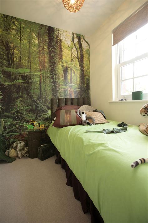 A Bedroom With A Green Bed And Wall Mural
