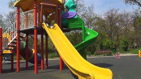 Child Playing Sliding On A Slide At Playground Stock Footage Video