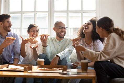 Happy Multiracial Friends Enjoying Home Party Time Eating Pizza Stock