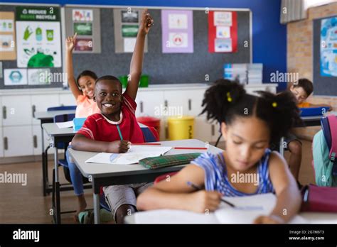 African American Boy And Girl Raising Their Hands While Sitting In The