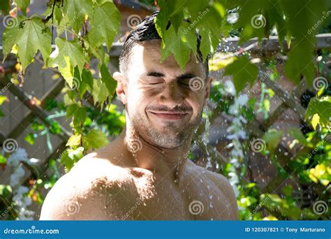 Handsome Semi Naked Man With Muscles And Bare Chest Caught In Shower Of Rain In Garden Stock