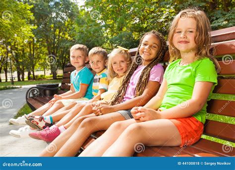Boys And Girls Sitting On The Bench In Park Stock Photo Image 44100818