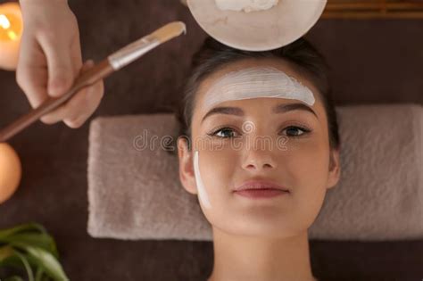 Beautician Applying Cosmetic Mask On Woman S Face In Spa Salon Stock