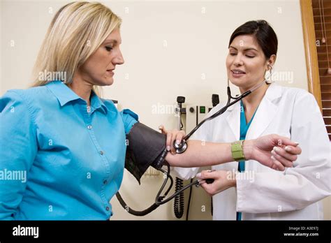 Female Patient Having Her Blood Pressure Taken During An Exam By A