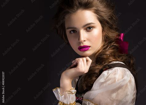 beautiful russian girl in national dress with a braid hairstyle and pink lips beauty face
