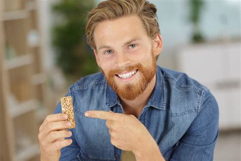 Handsome Young Man Eating Cereal Bar Stock Image Image Of Cereal Enjoying 257191751