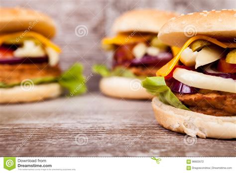 Close Up Of Delicious Home Made Burgers On Wooden Plate Stock Photo