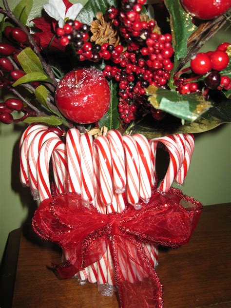 Candy Canes Wrapped In Red And White Ribbon Sit On A Table Next To