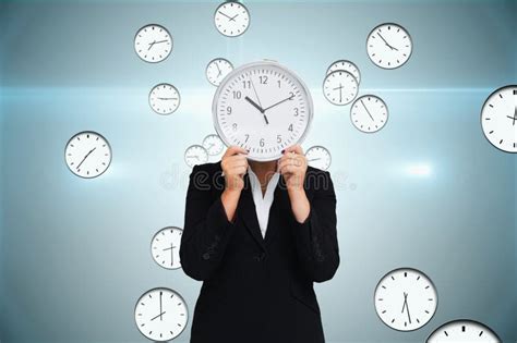 Business Woman Holding A Clock Against Background With Clocks Stock