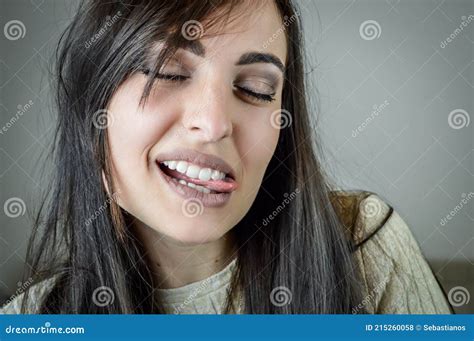 Portrait Of A Beautiful Young Woman With Long Brown Hair Grimacing And Sticking Out The Tongue