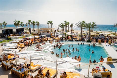 Guests enjoy the beach locale. 7 Dubai Beach Club Hotspots That We're Loving in 2018 | insydo