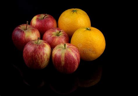 Oranges And Apple Fruits On A Reflective Black Surface Stock Photo