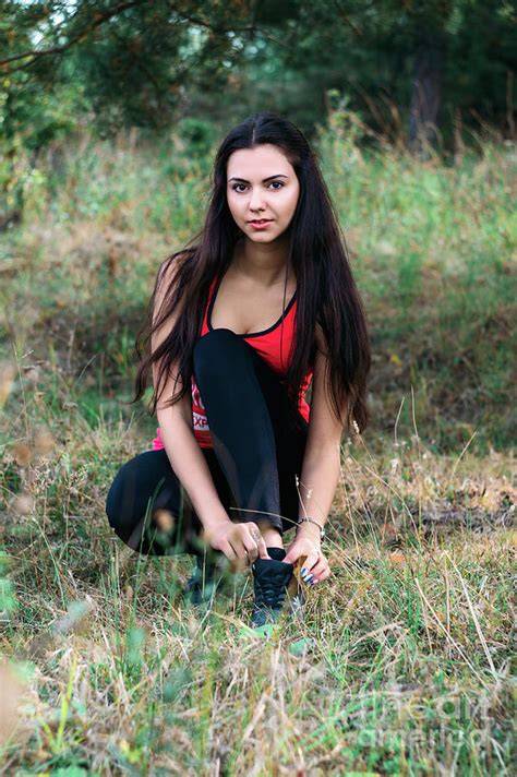 Young Beautiful Brunette Tying Shoes While Jogging Photograph By