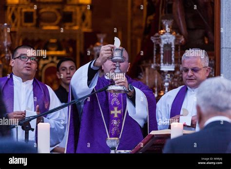 Priest Celebrating Mass Holding The Host And Chalice Of Wine